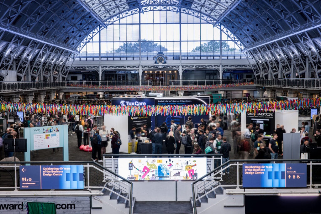 Attendees networking and visiting exhibitor booths at Devoxx Belgium