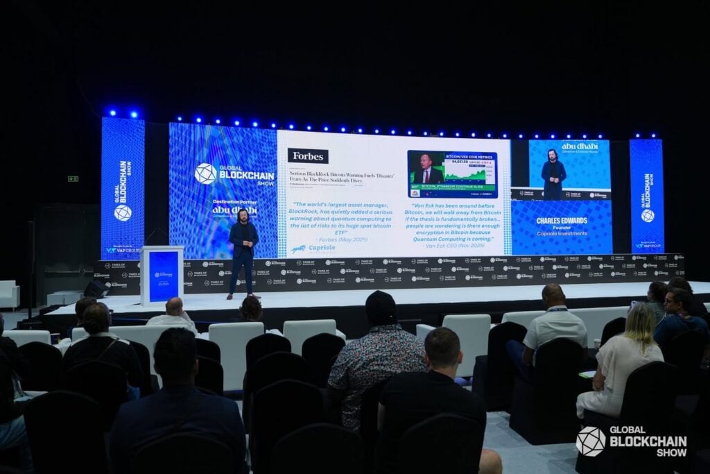 Speaker presenting on stage to an audience at Global Blockchain Show