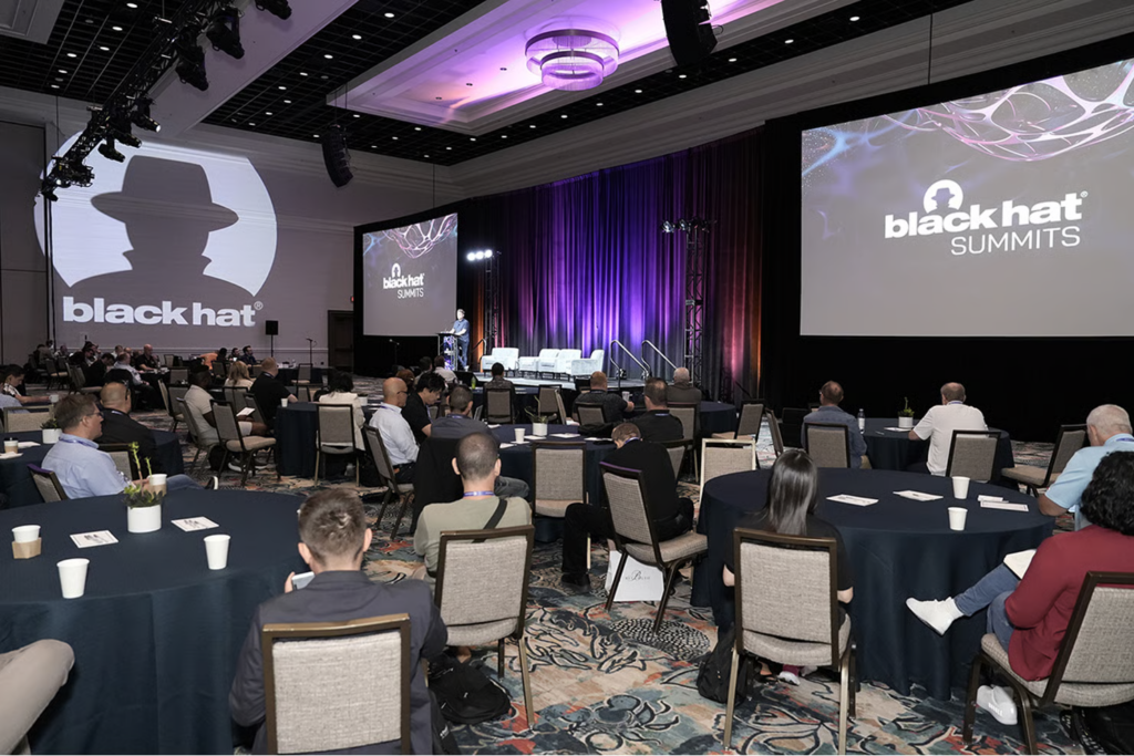 Black Hat USA summit session with attendees listening to a cybersecurity presentation
