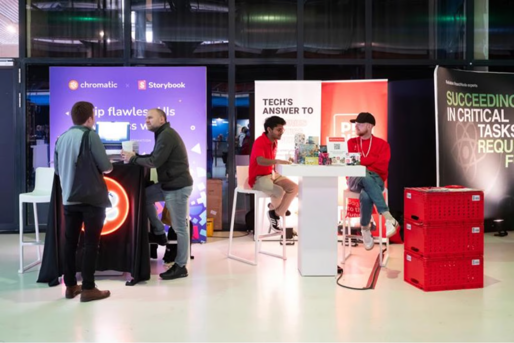 Attendees networking and exploring exhibitor booths at the React Day Berlin conference