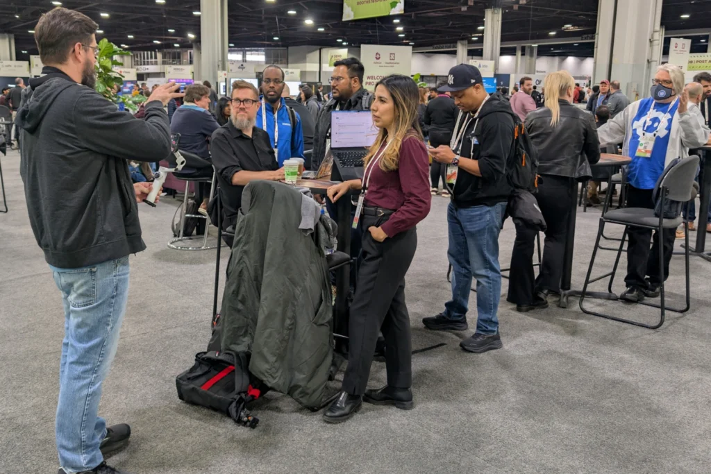 Professionals networking and collaborating on the expo floor during KubeCon + CloudNativeCon North America