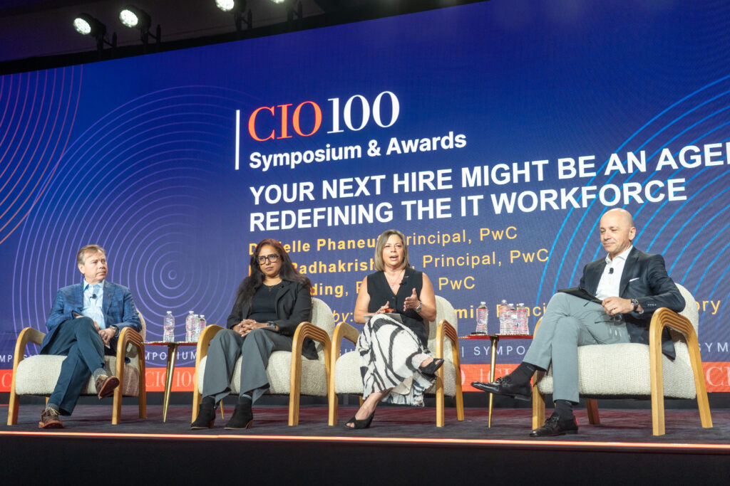 Panel discussion on stage during the CIO100 Symposium & Awards with speakers addressing IT and technology leadership topics.