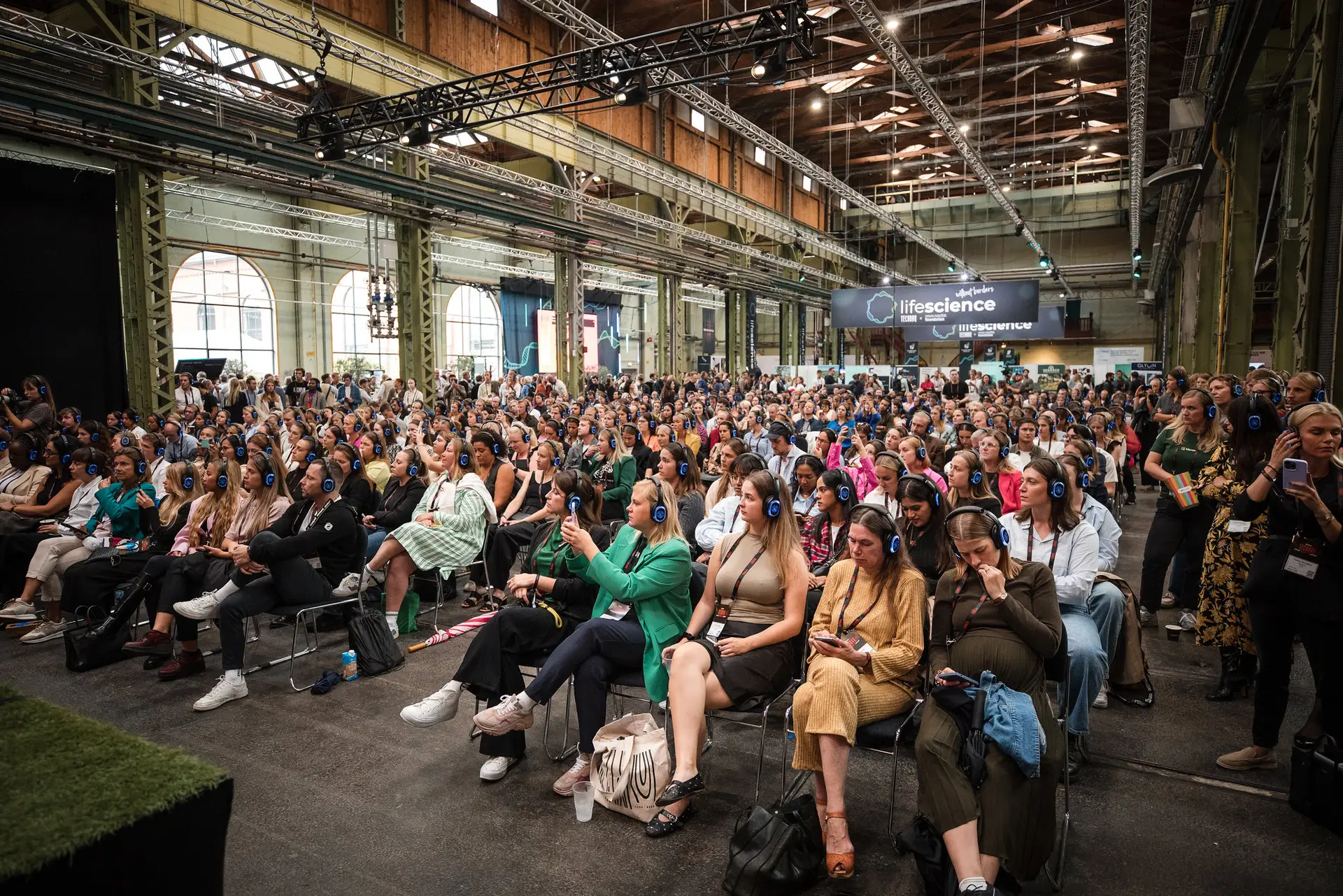 Ampio pubblico che partecipa a una sessione sul palco alla conferenza startup TechBBQ